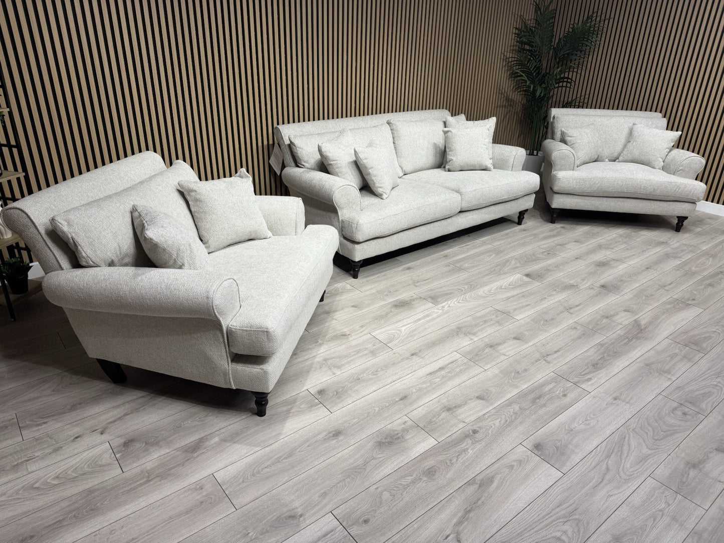 Gray sofa set in a room with wooden flooring and striped walls
