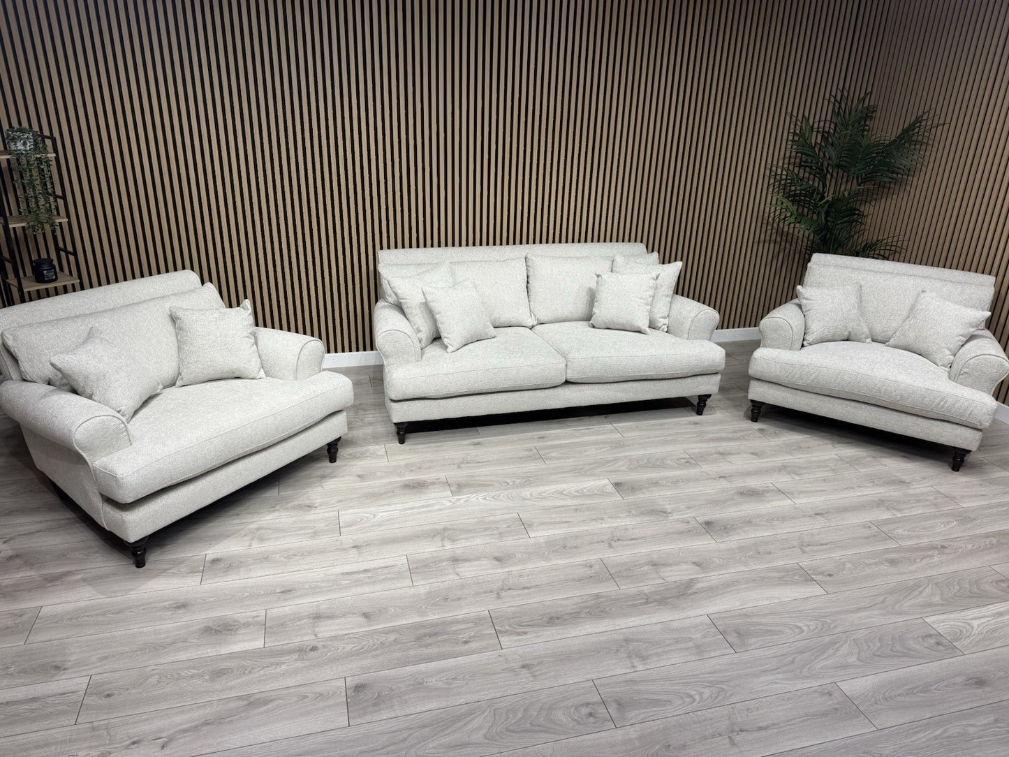 White leather sofa set in a room with wooden flooring and striped wallpaper.