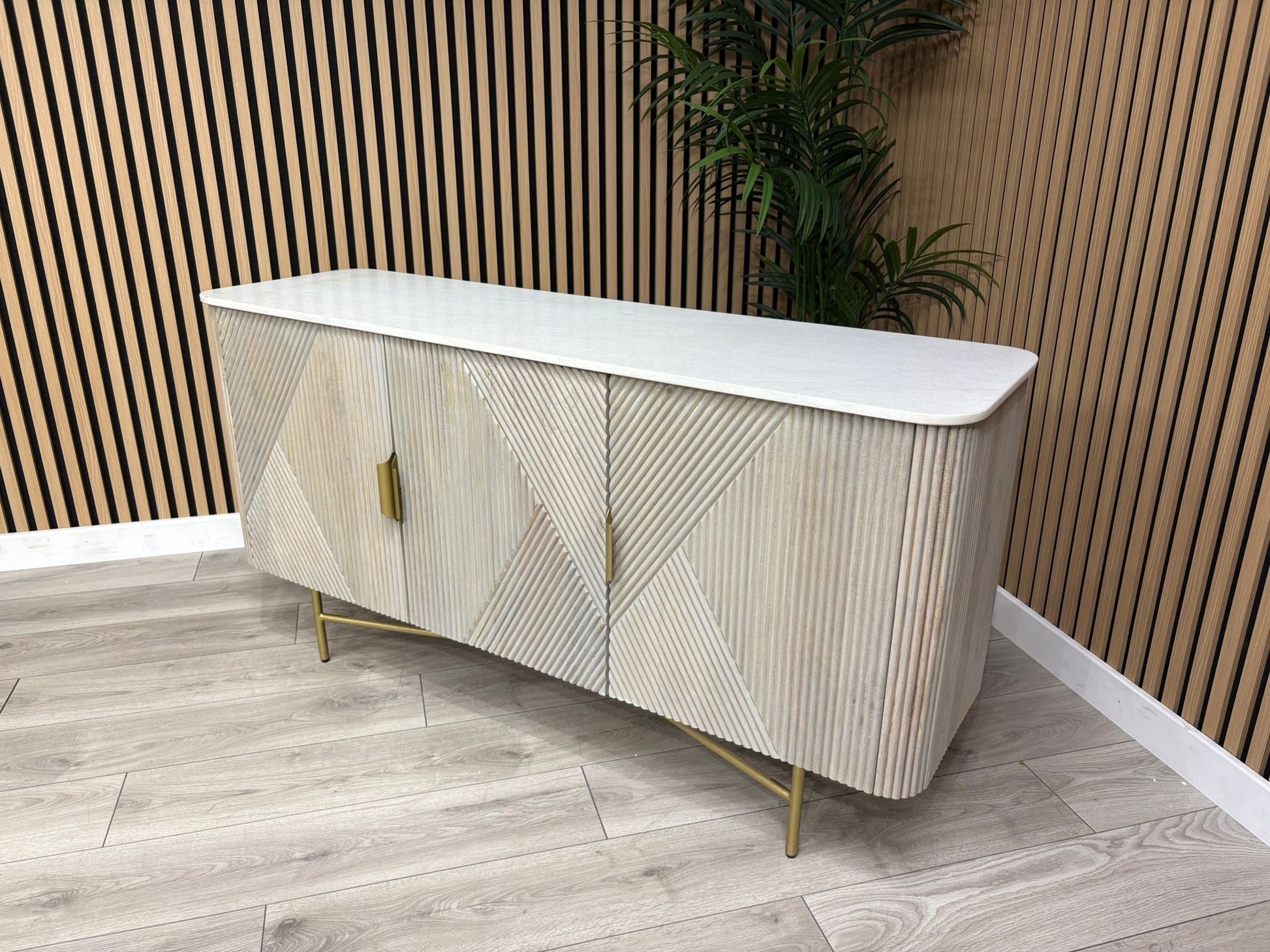 Modern sideboard with geometric design in a room with wooden floor and wall.