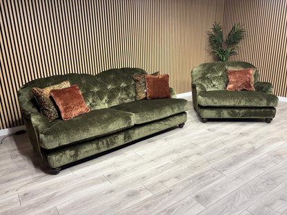 Green velvet sofa with decorative pillows on a wooden floor.