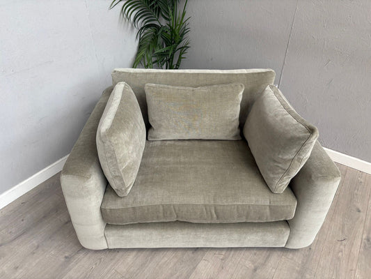 Beige sofa with cushions against a gray wall